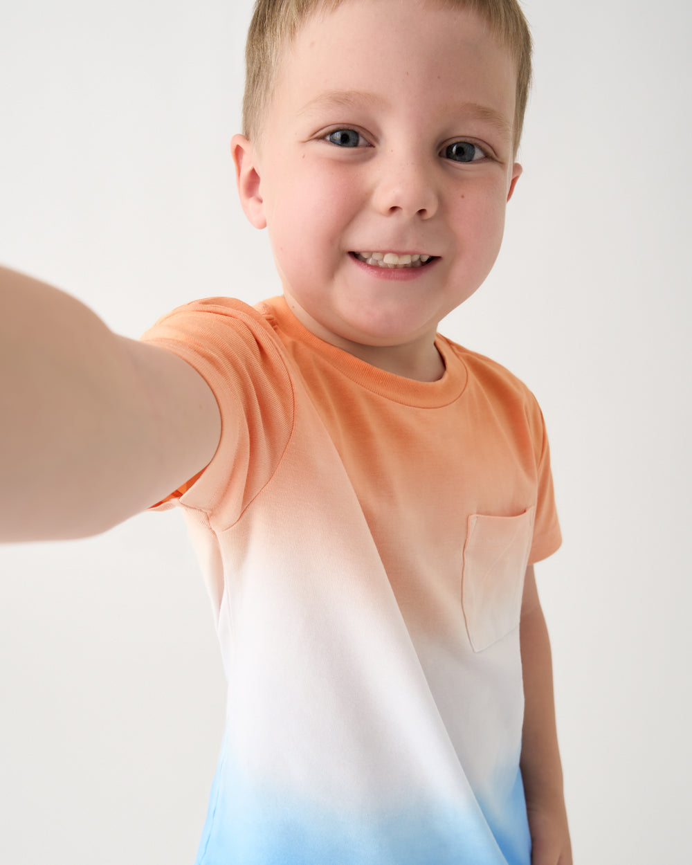 Close up of boy wearing the Orange Crush Relaxed Pocket Tee