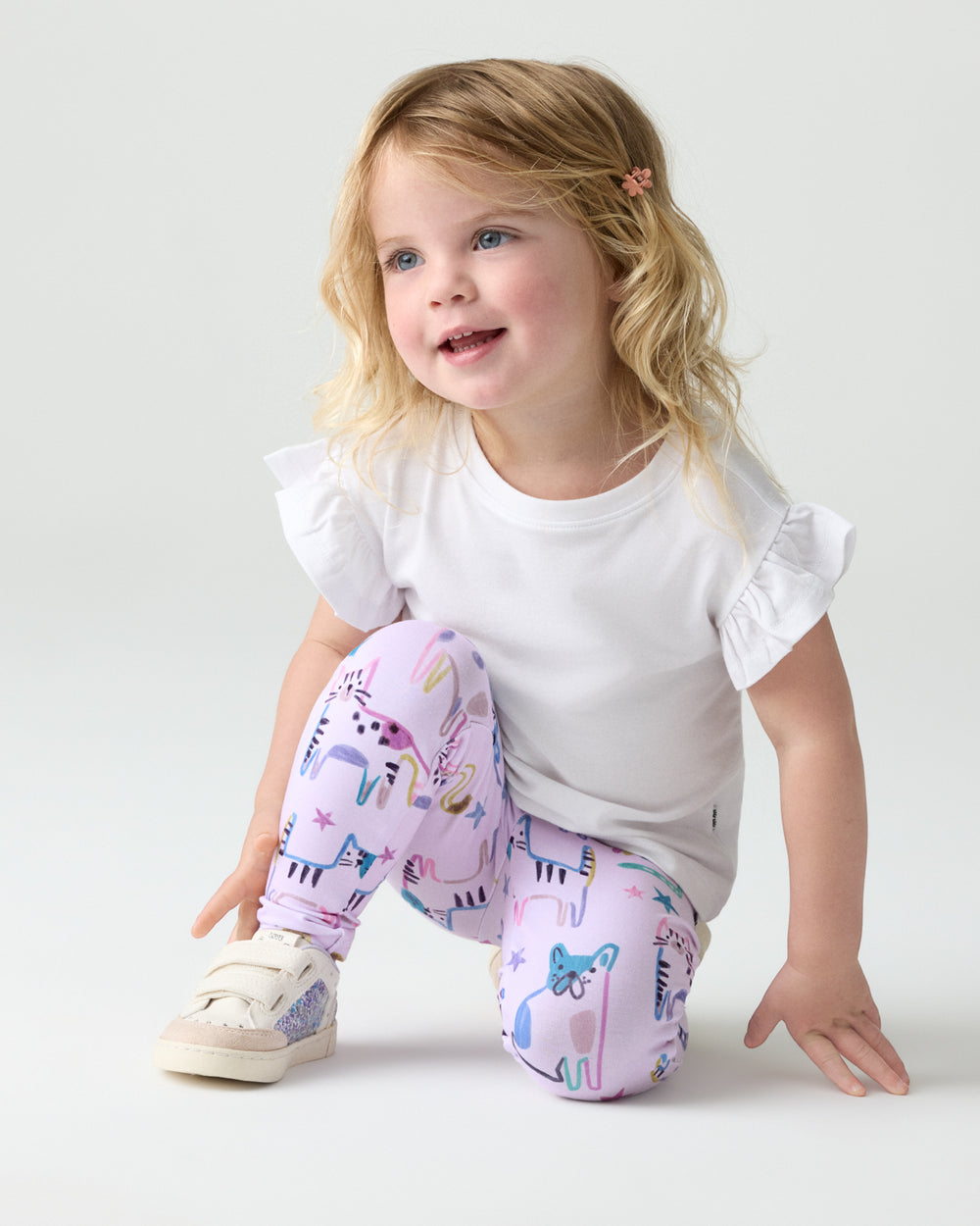 Crouching child wearing the Whiskers & Wags Purple Legging with a white top
