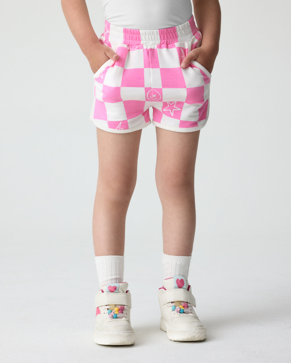 Girl wearing the Cheery Checks Pink Dolphin Shorts with sneakers