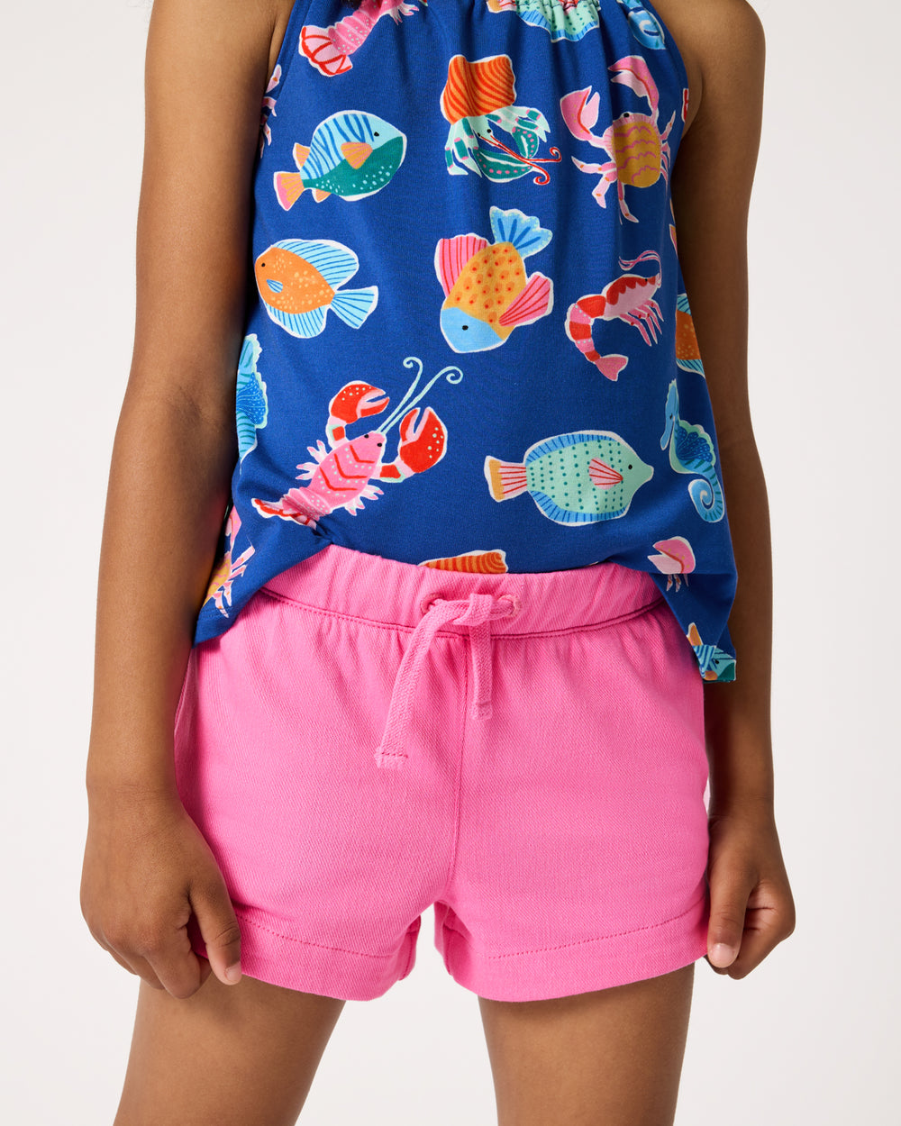 Child wearing the Pink Spark Denim Shorts with an ocean themed tank