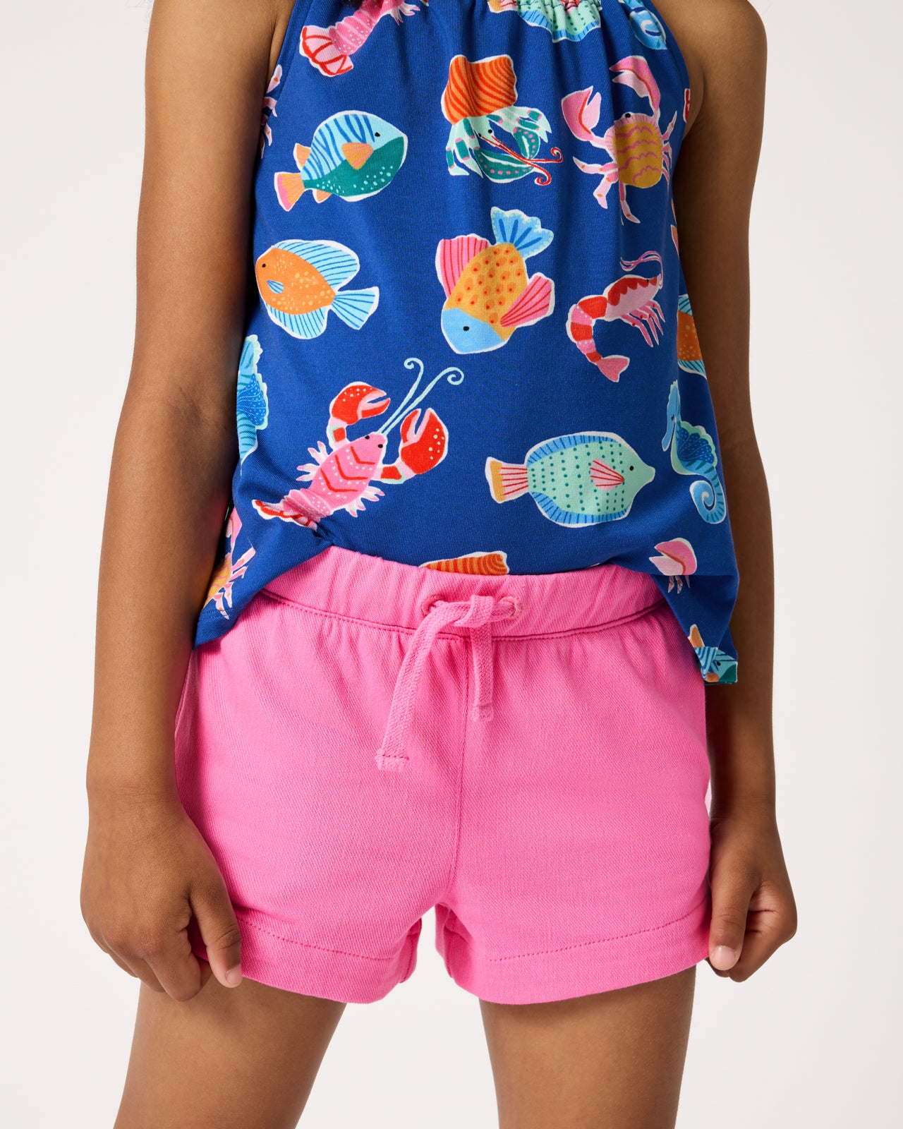 Child wearing the Pink Spark Denim Shorts with an ocean themed tank