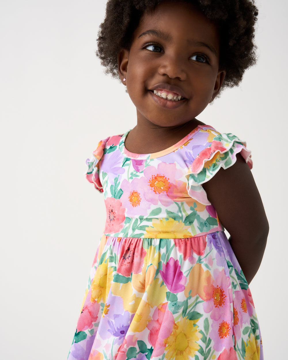 Close up of girl wearing the Watercolor Meadow Flutter Twirl Dress