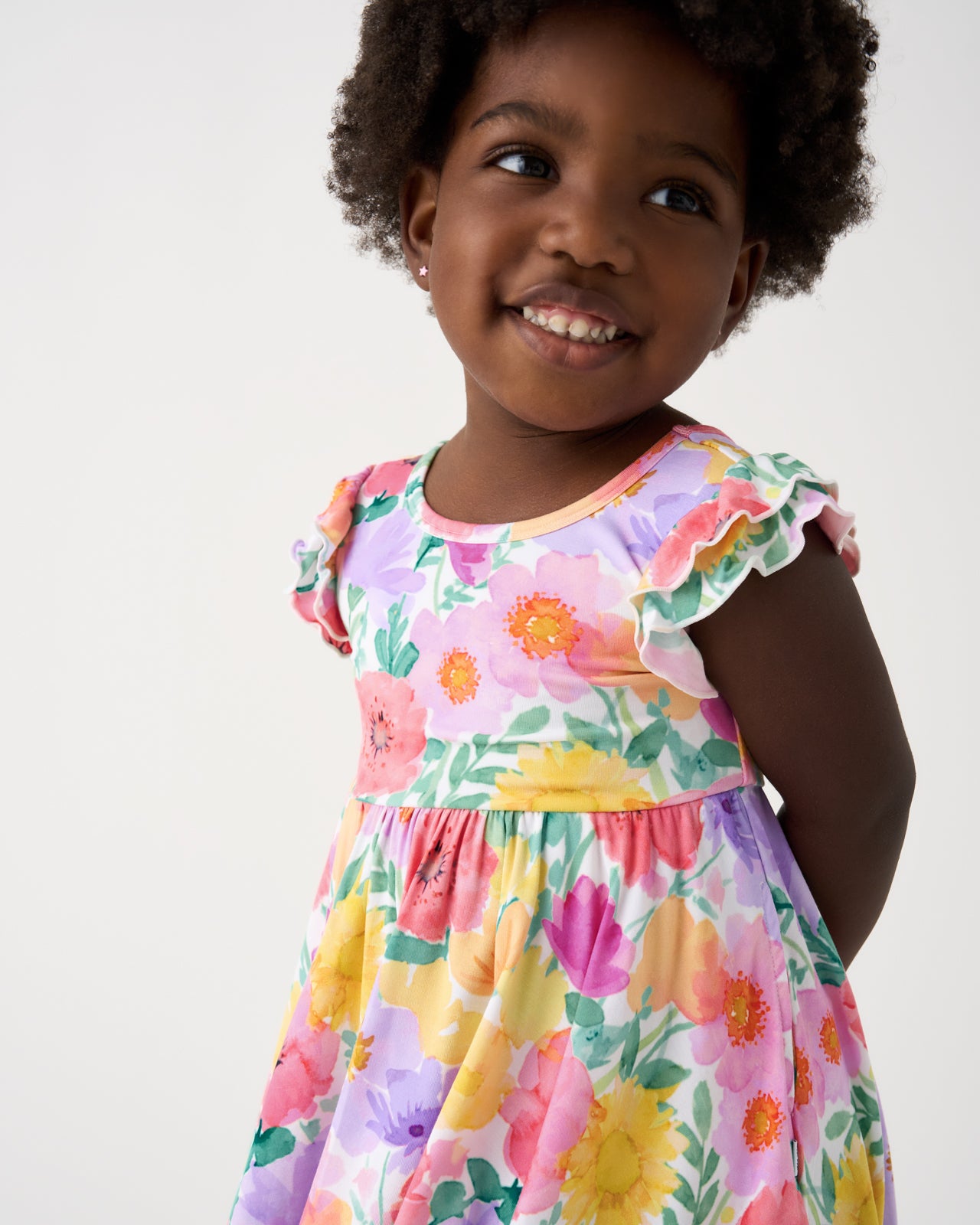 Close up of girl wearing the Watercolor Meadow Flutter Twirl Dress