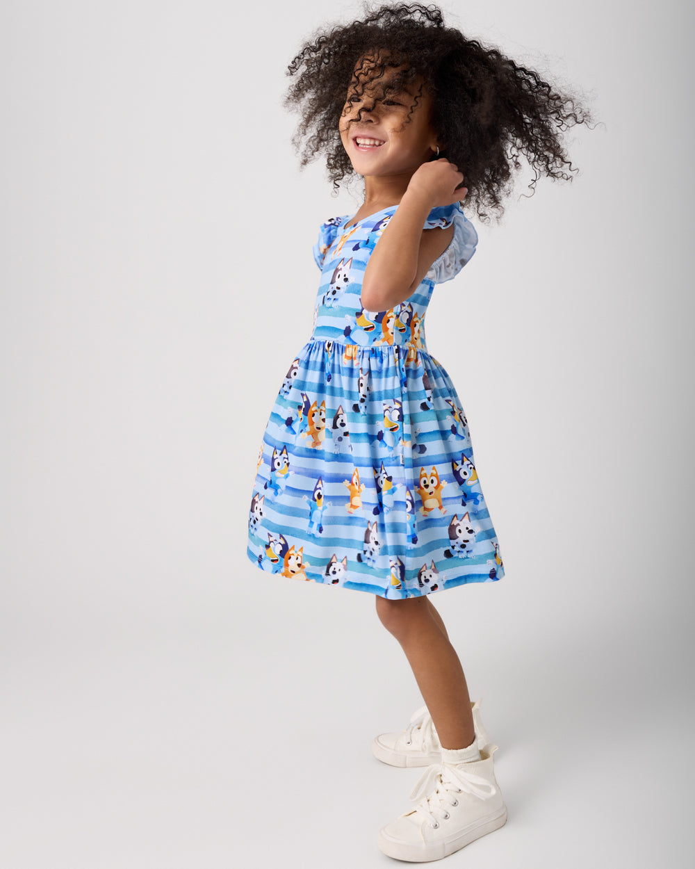 Child in motion wearing the Bluey Dance All Day Flutter Skater Dress