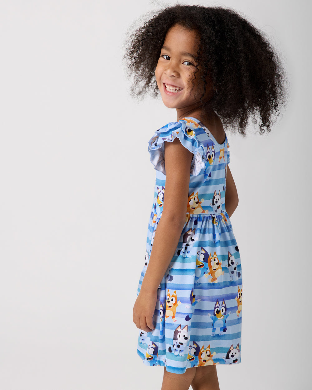 Side view of girl wearing the Bluey Dance All Day Flutter Skater Dress