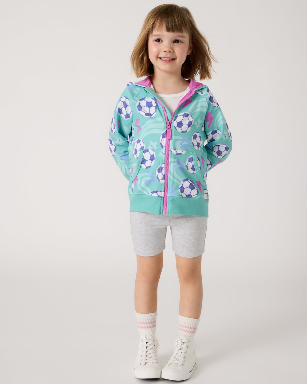 Girl wearing the Aqua Soccer Stars Zip Hoodie with gray biker shorts