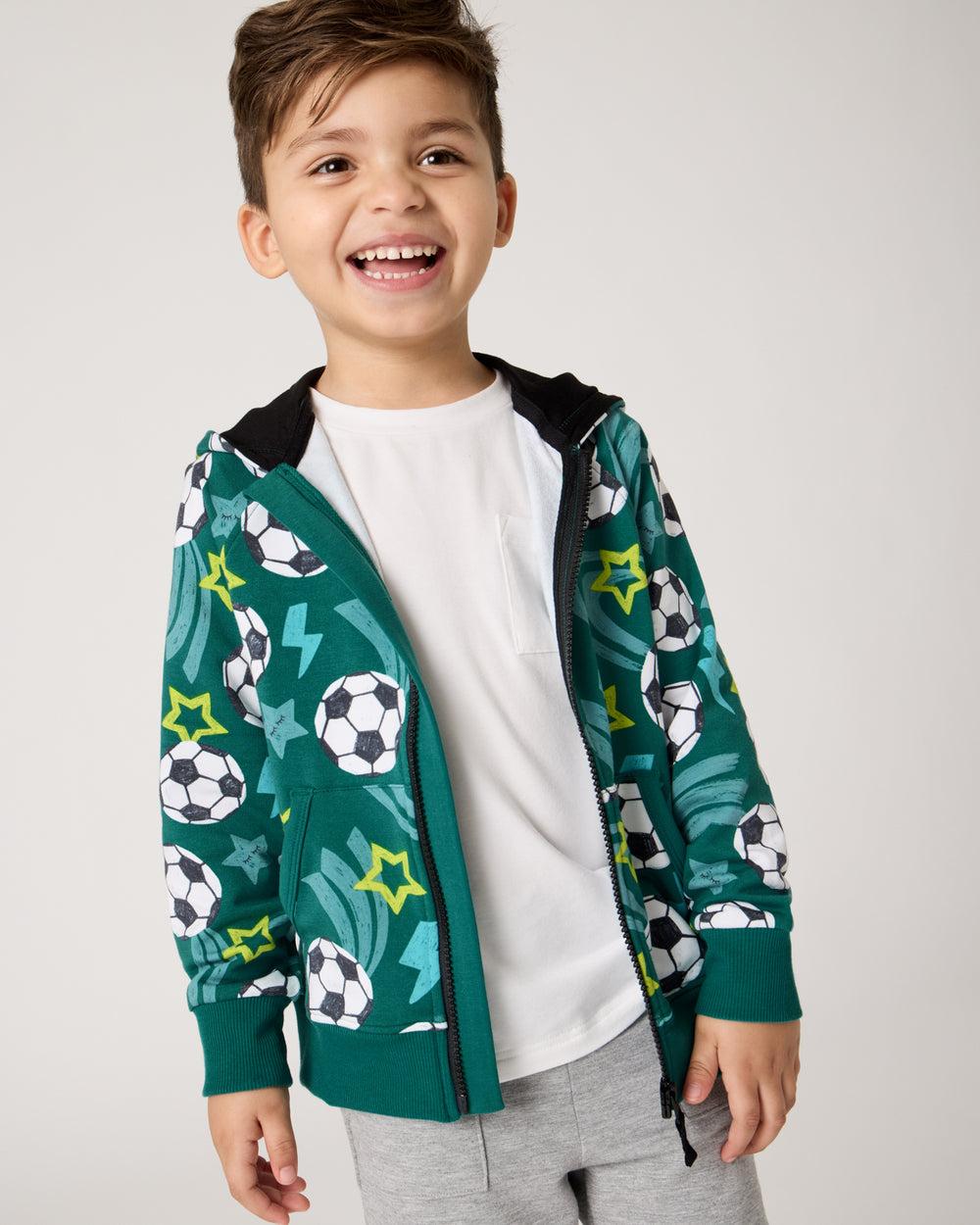 Boy wearing the Soccer Stars Zip Hoodie layered over the Soccer Stars Zip Hoodie