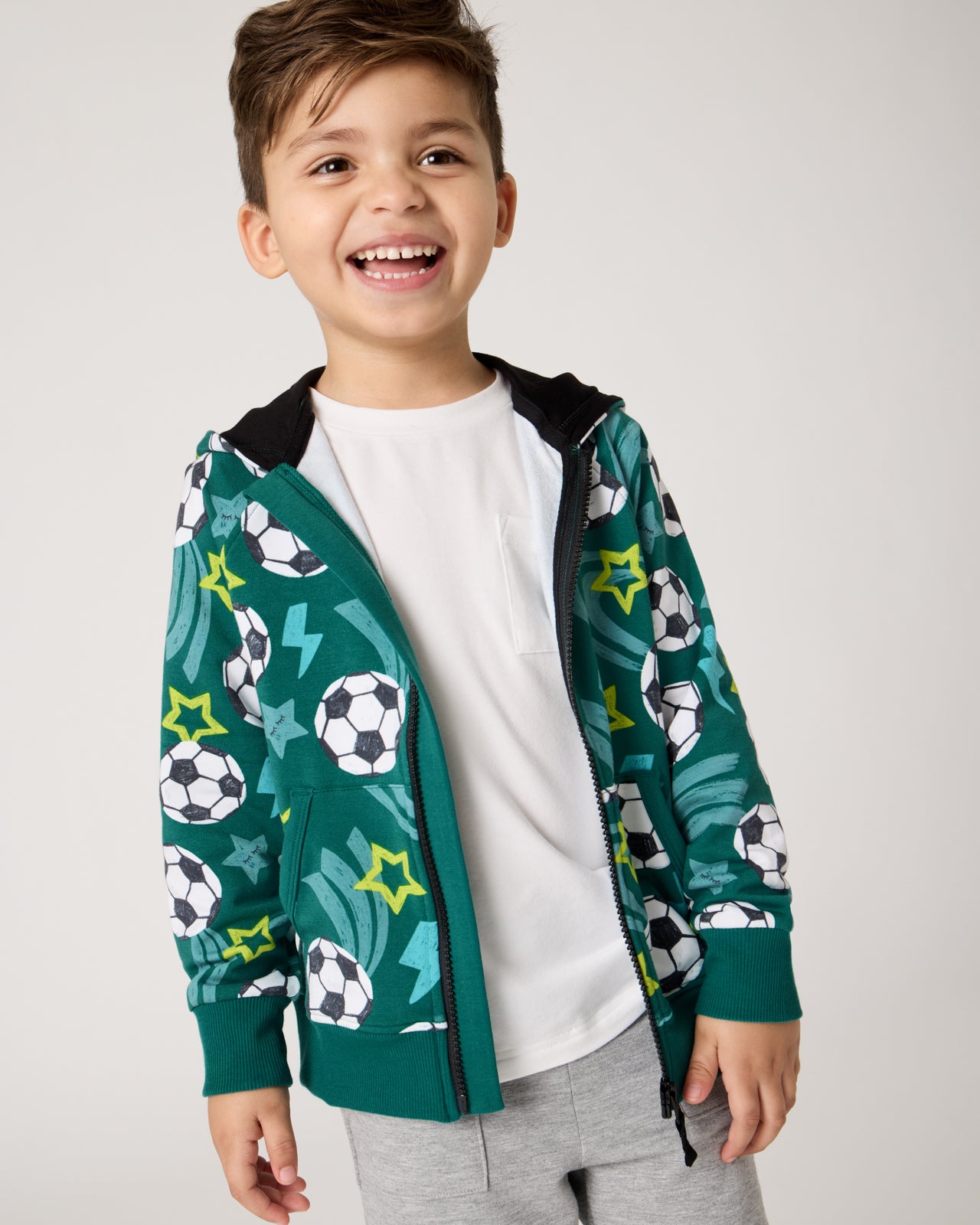 Boy wearing the Soccer Stars Zip Hoodie layered over the Soccer Stars Zip Hoodie