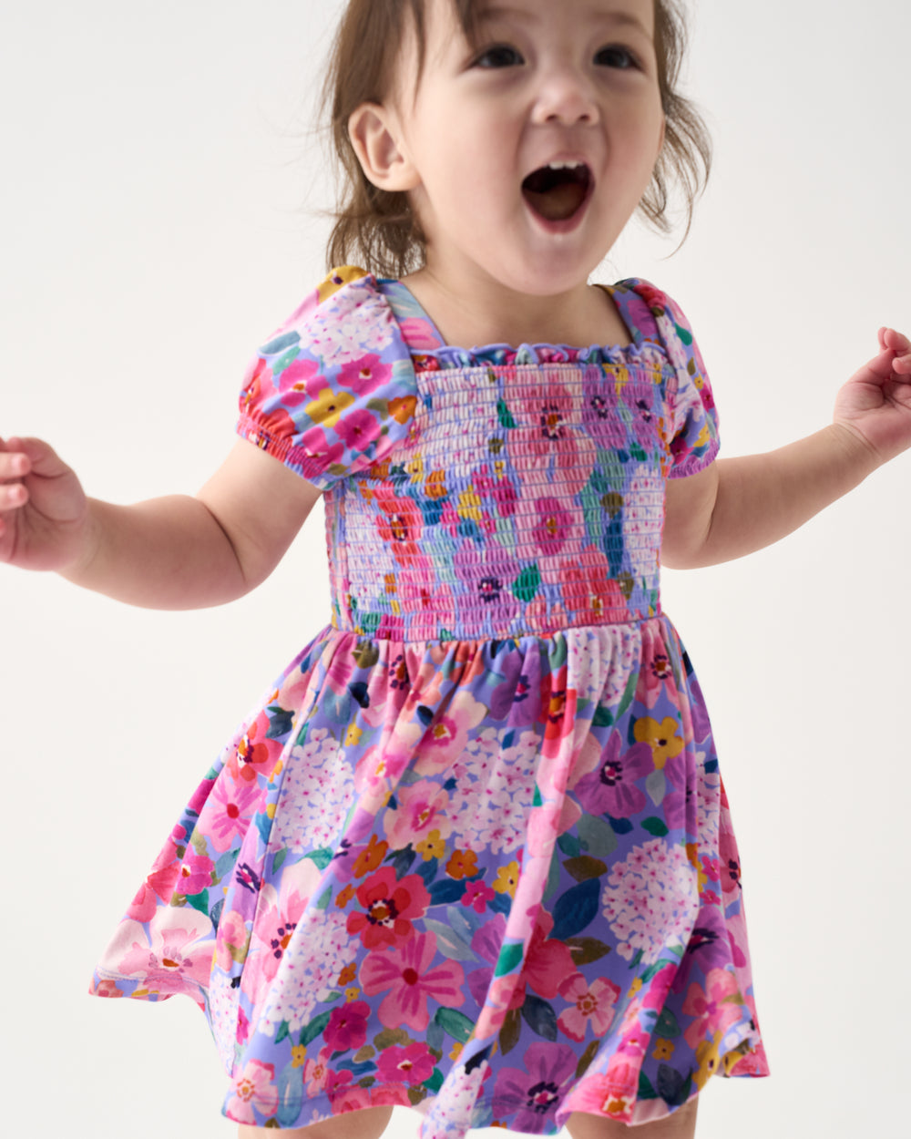 Close up of child wearing the Sweet Sprigs Puff Sleeve Smocked Dress with Bloomer