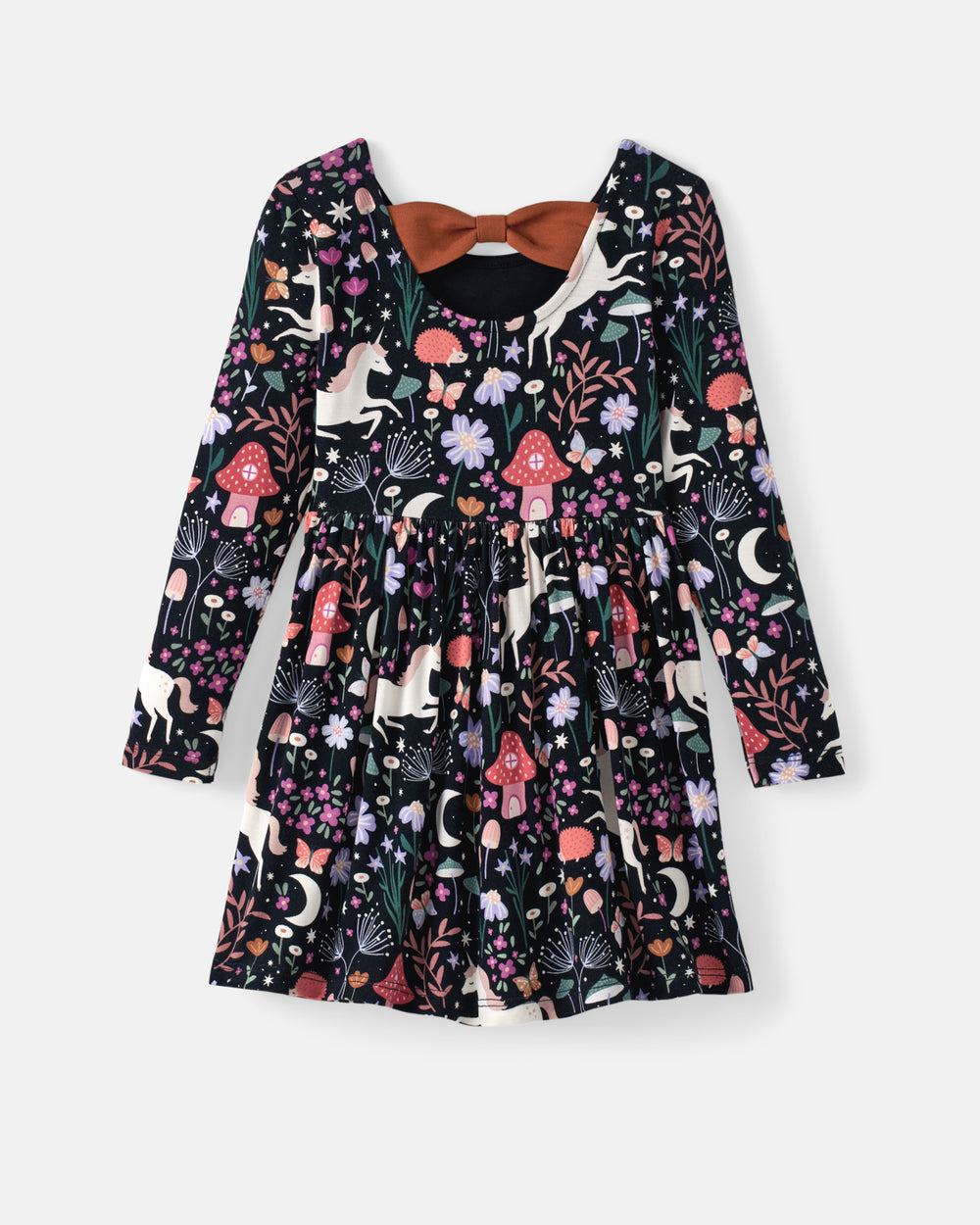 A long-sleeve children's dress with a whimsical woodland print featuring mushrooms, flowers, and moons on a black background, styled with a brown bow tie at the back.