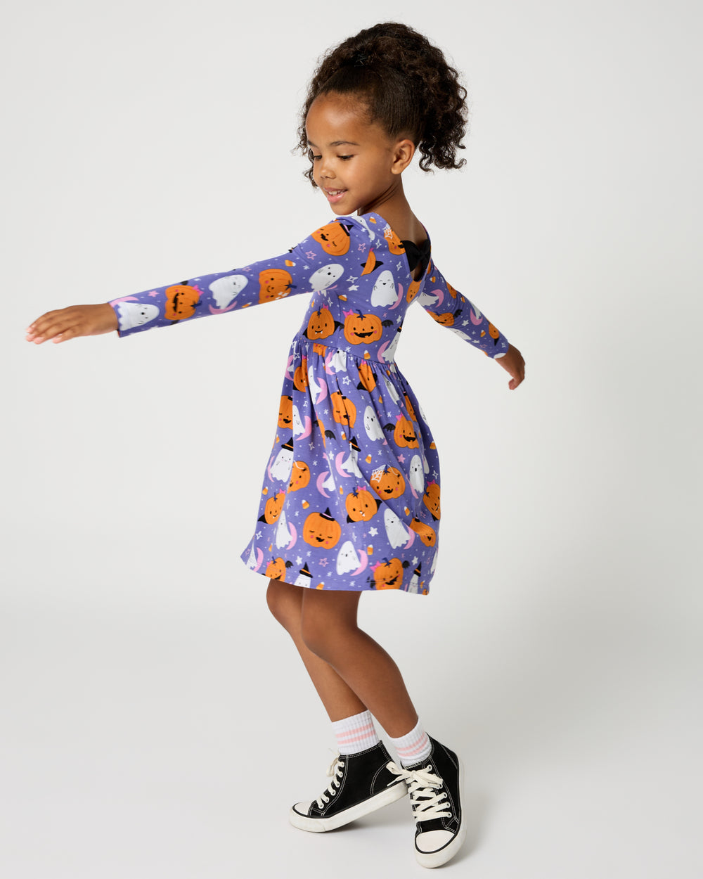 Child in motion wearing the Moonlit Magic Purple Bow Back Skater Dress