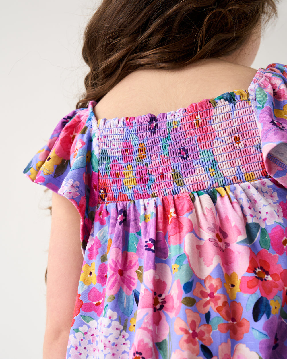 Back view of girl wearing the Sweet Sprigs Smocked Flutter Top