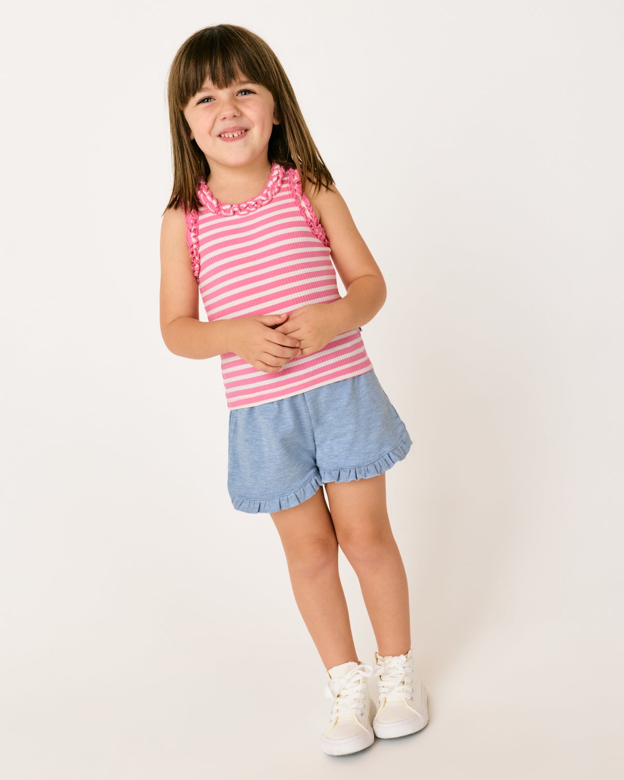 Girl wearing the Heather Blue Ruffle Shorts with a pink striped tank