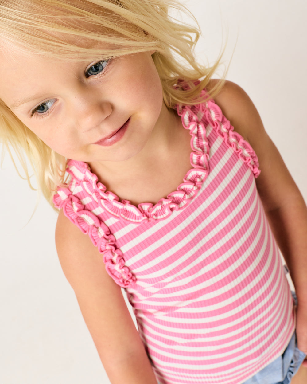 Close up of girl wearing the Sweet Pink Stripe Ruffle Tank
