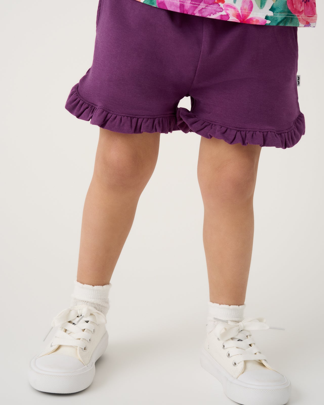 Close up of girl wearing the Royal Violet Ruffle Shorts with white sneakers