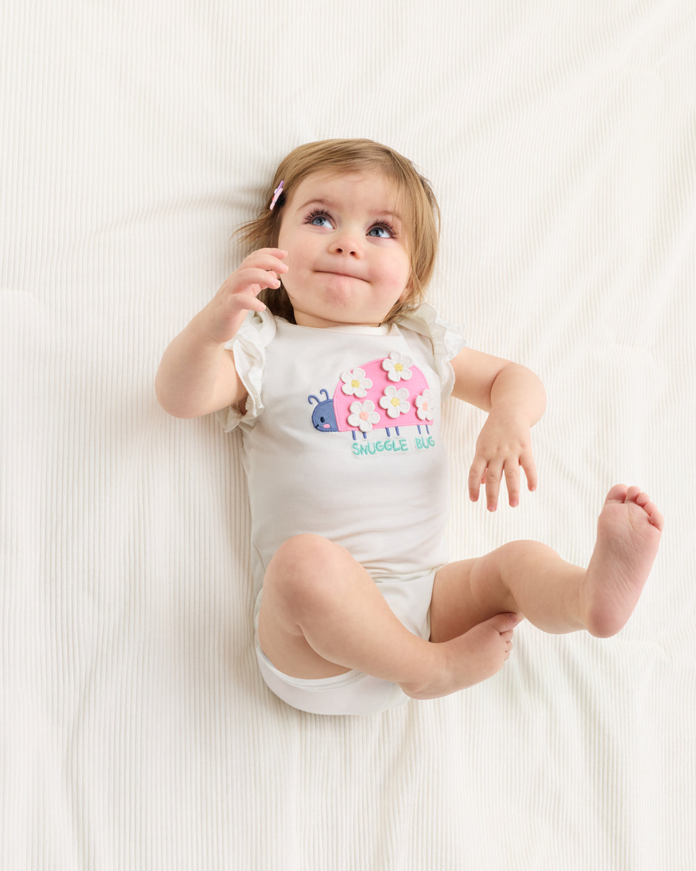 Aerial view of baby wearing the Snuggle Bug Flutter Bodysuit