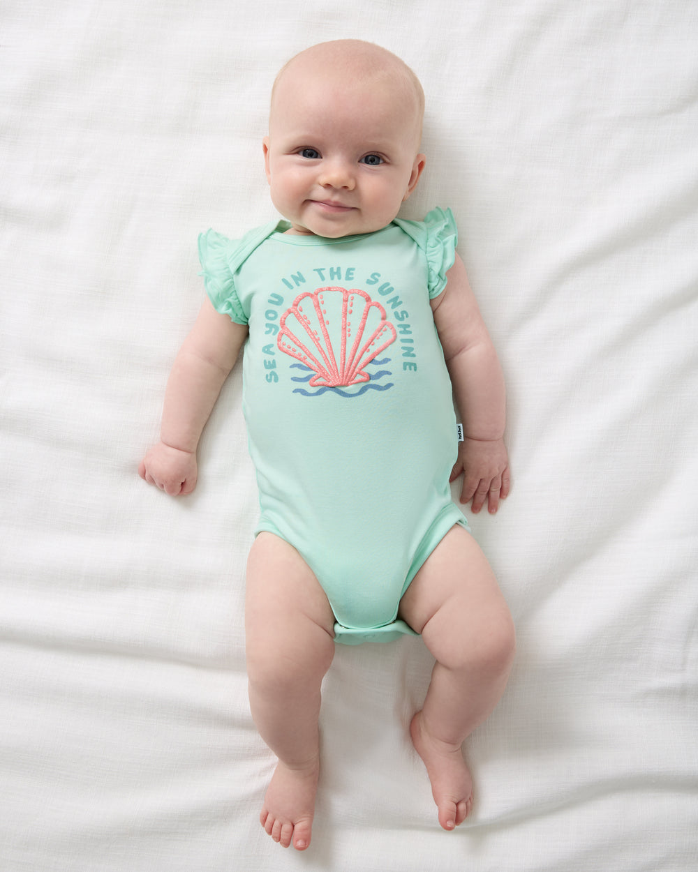 Aerial view of baby wearing the Sparkling Seas Flutter Bodysuit