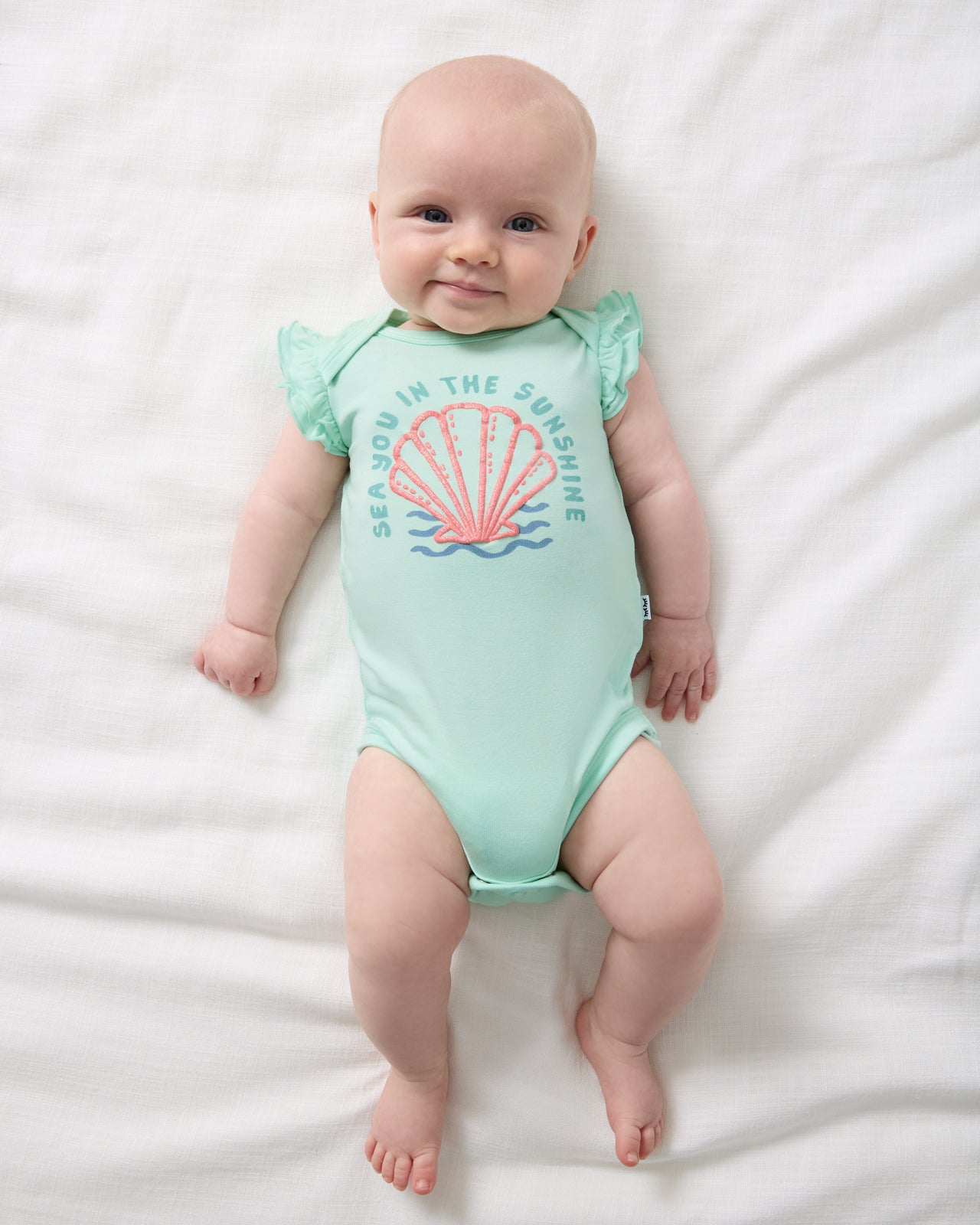 Aerial view of baby wearing the Sparkling Seas Flutter Bodysuit