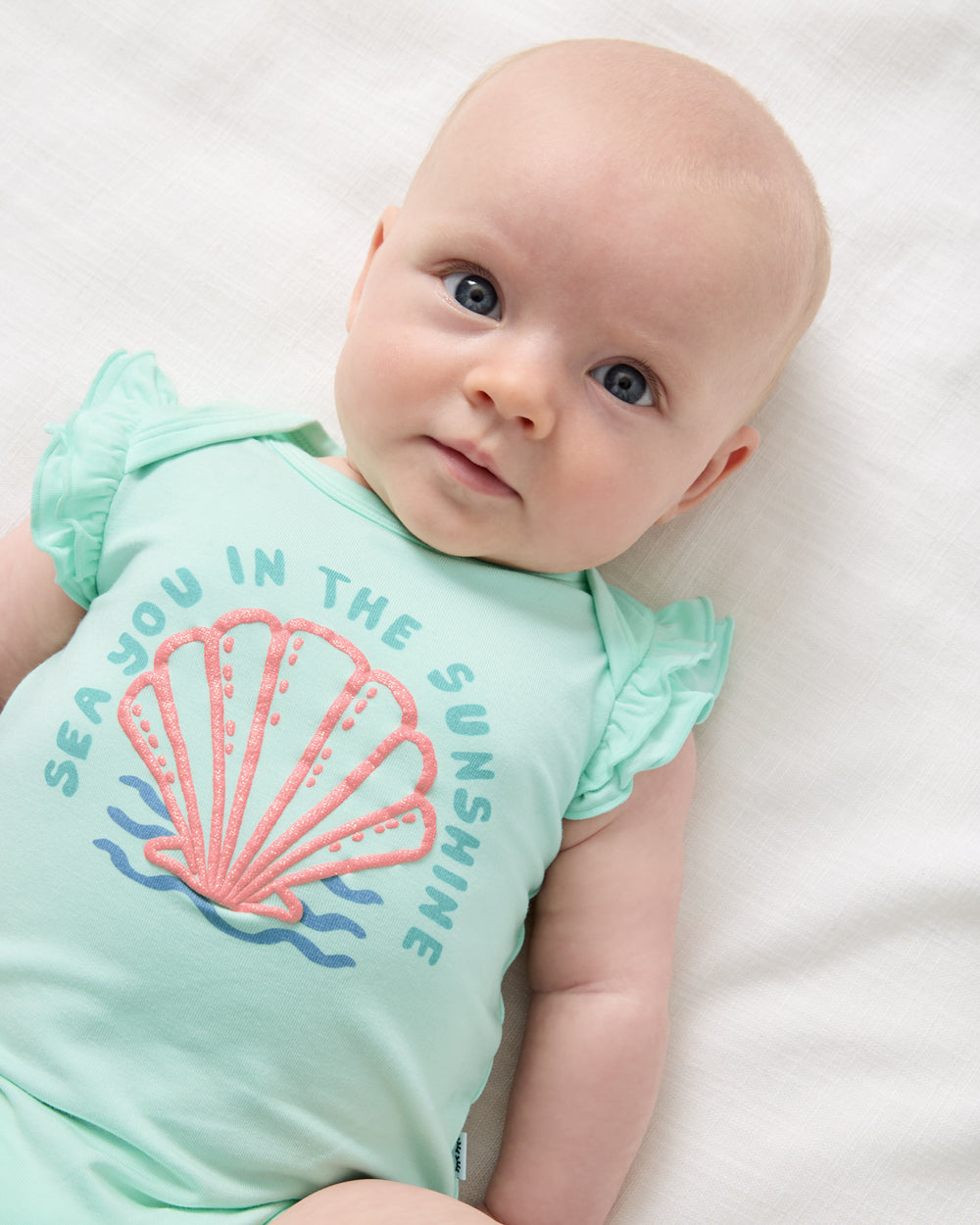 Close up of newborn wearing the Sparkling Seas Flutter Bodysuit