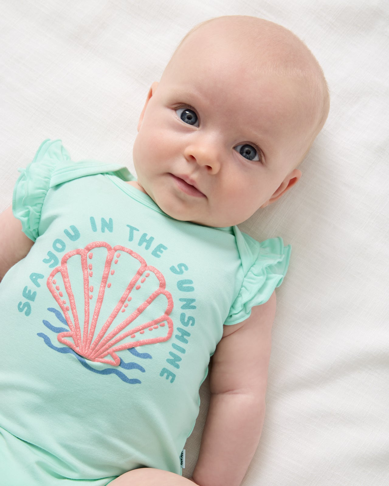 Close up of newborn wearing the Sparkling Seas Flutter Bodysuit