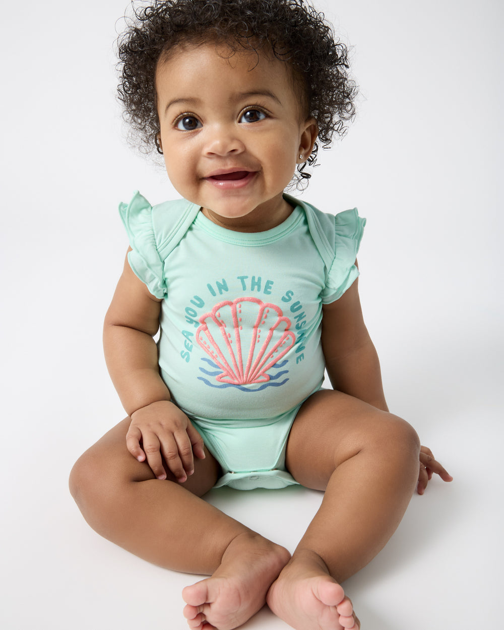 Sitting baby wearing the Sparkling Seas Flutter Bodysuit