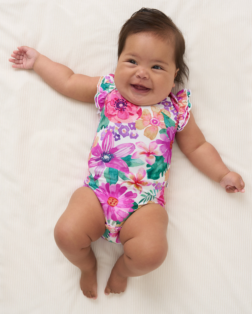 Aerial view of baby wearing the Hibiscus Blooms Flutter Bodysuit