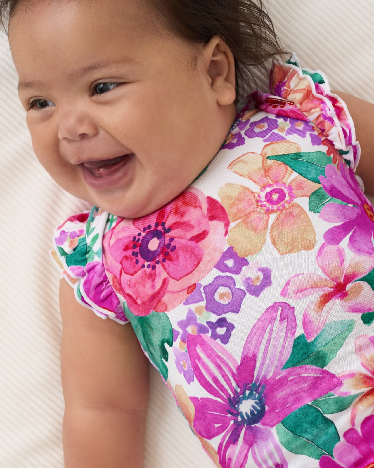 Close up of baby wearing the Hibiscus Blooms Flutter Bodysuit