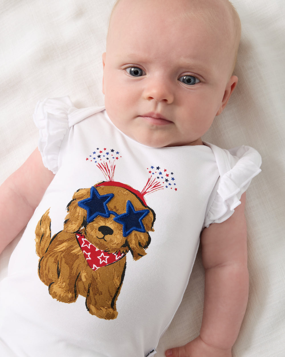 Close up of baby wearing the Star Spangled Pup Flutter Bodysuit