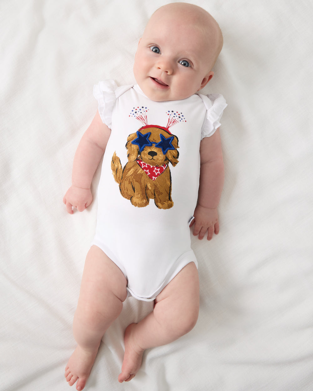 Aerial view of newborn wearing the Star Spangled Pup Flutter Bodysuit