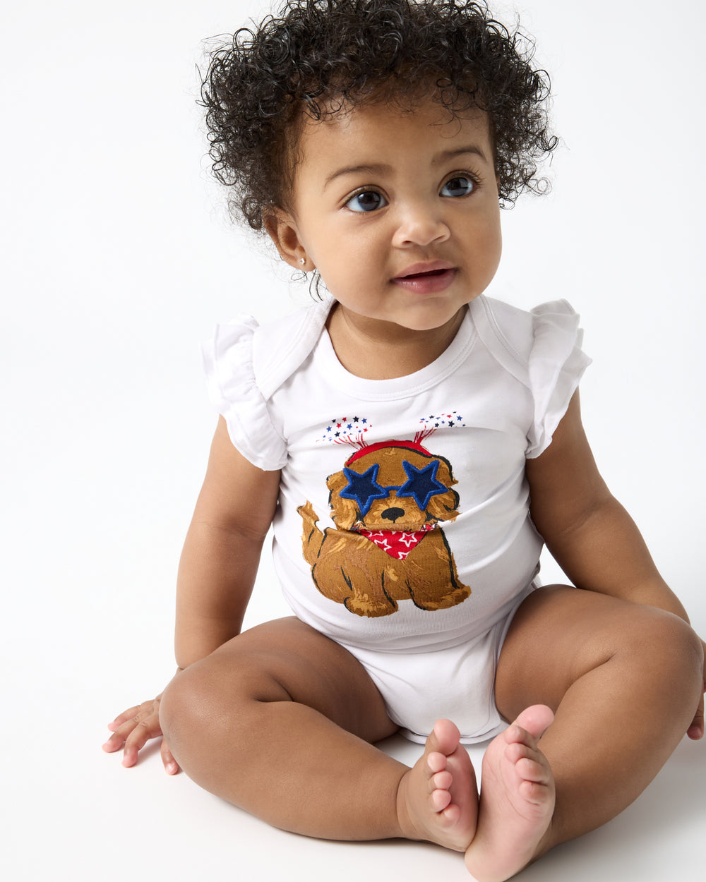 Sitting baby wearing the Star Spangled Pup Flutter Bodysuit