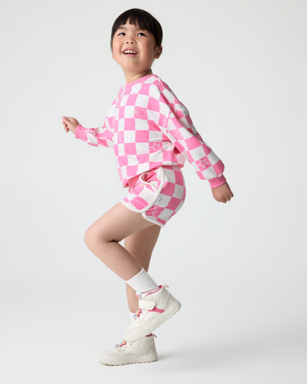 Child in motion wearing the Cheery Checks Pink Dolphin Shorts and Crewneck Sweatshirts