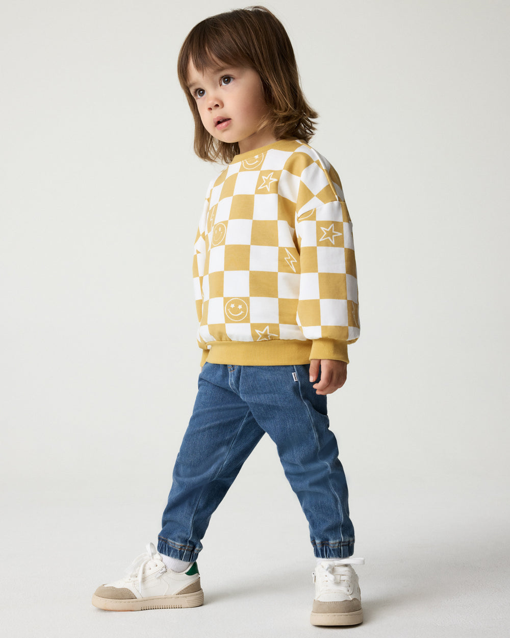 Child wearing the Cheery Checks Drop Shoulder Sweatshirt with denim joggers