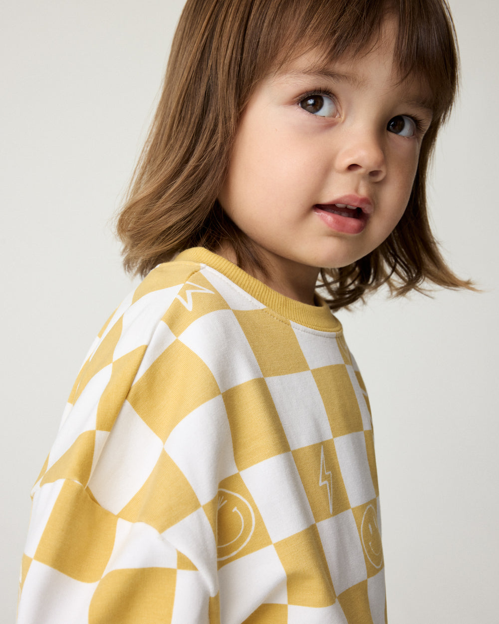 Close up of child wearing the Cheery Checks Drop Shoulder Sweatshirt
