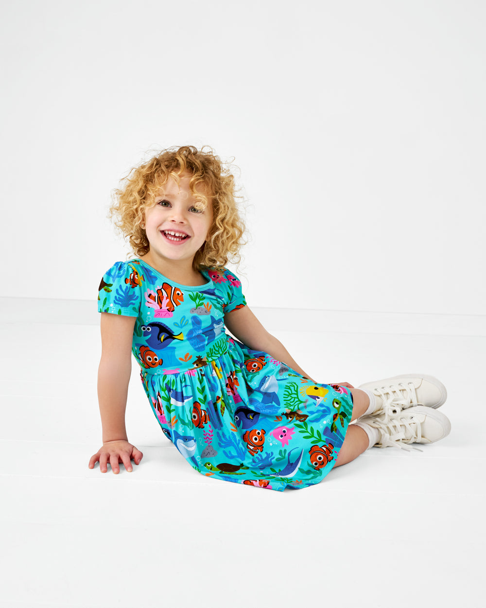 Sitting child wearing the Disney Nemo's Reef Skater Dress