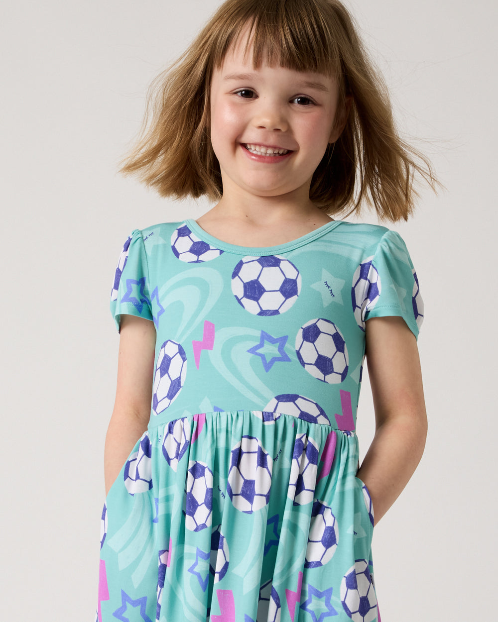 Close up of girl wearing the Aqua Soccer Stars Skater Dress