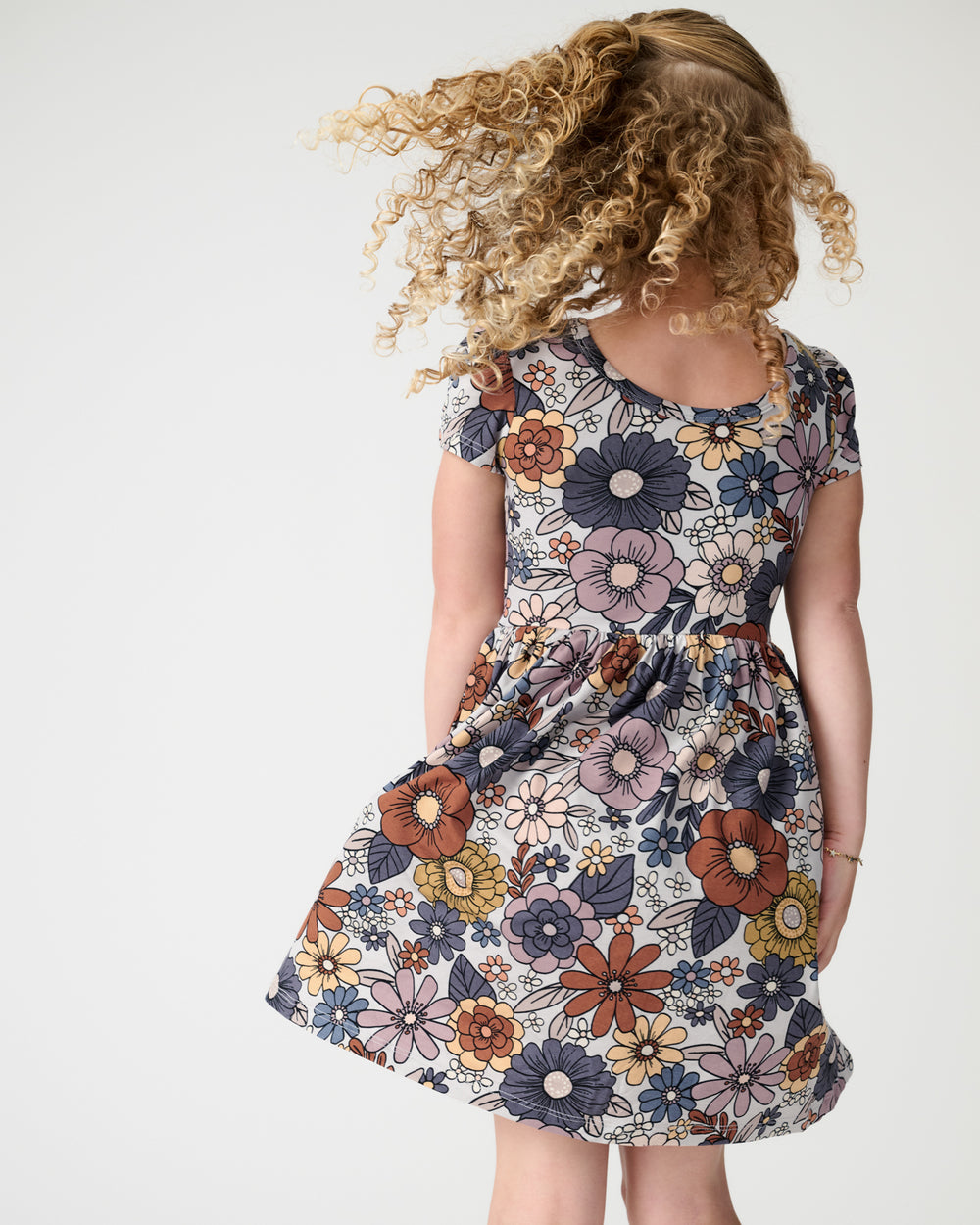 Back view of girl wearing the Wildwood Floral Skater Dress