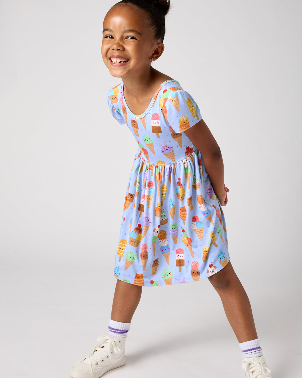 Girl wearing the Scoop Squad Skater Dress with white sneakers