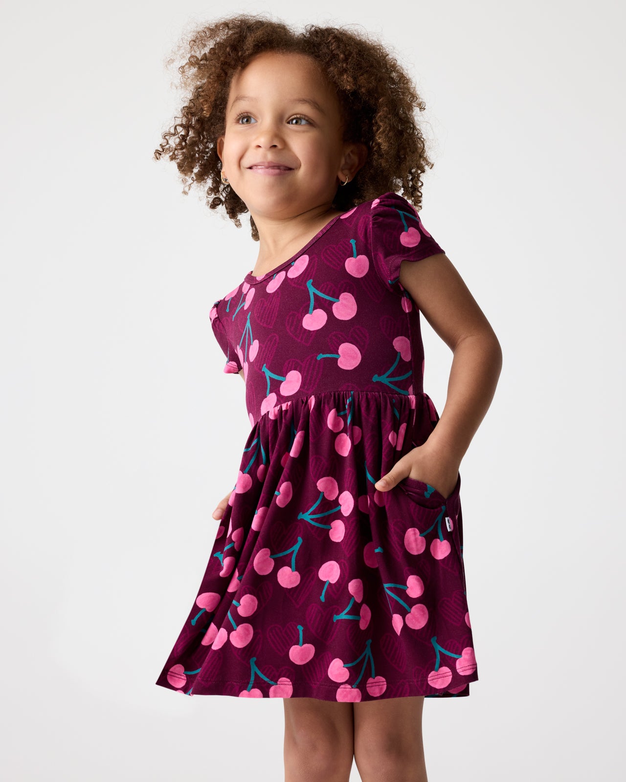 Girl wearing the Cherry Charm Skater Dress with her hand in the pocket