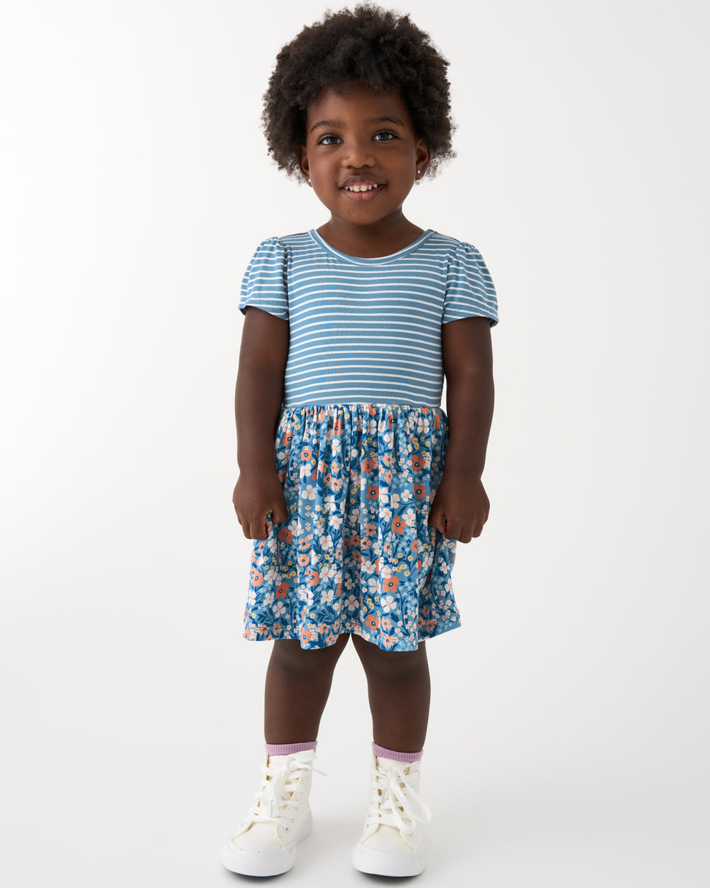 Standing girl wearing the Petite Petals Skater Dress
