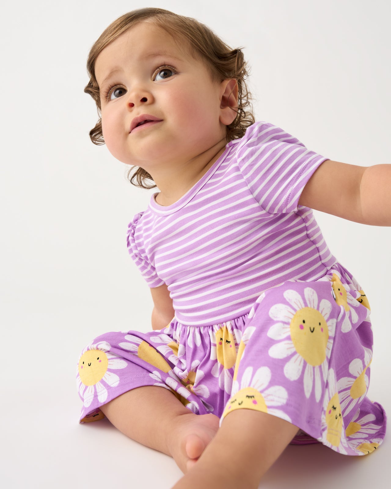 Sitting baby wearing the Flower Power Skater Dress with Bodysuit