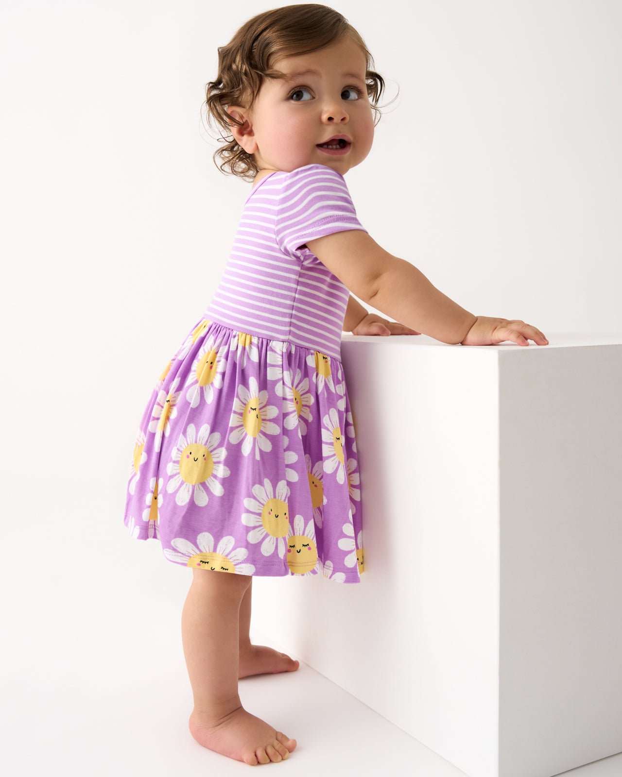 Standing baby wearing the Flower Power Skater Dress with Bodysuit