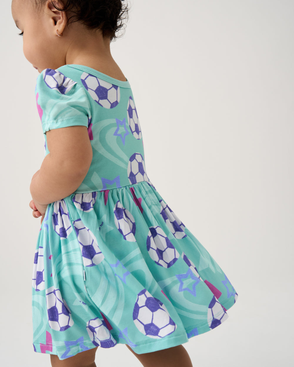 Back view of baby wearing the Aqua Soccer Stars Skater Dress with Bodysuit