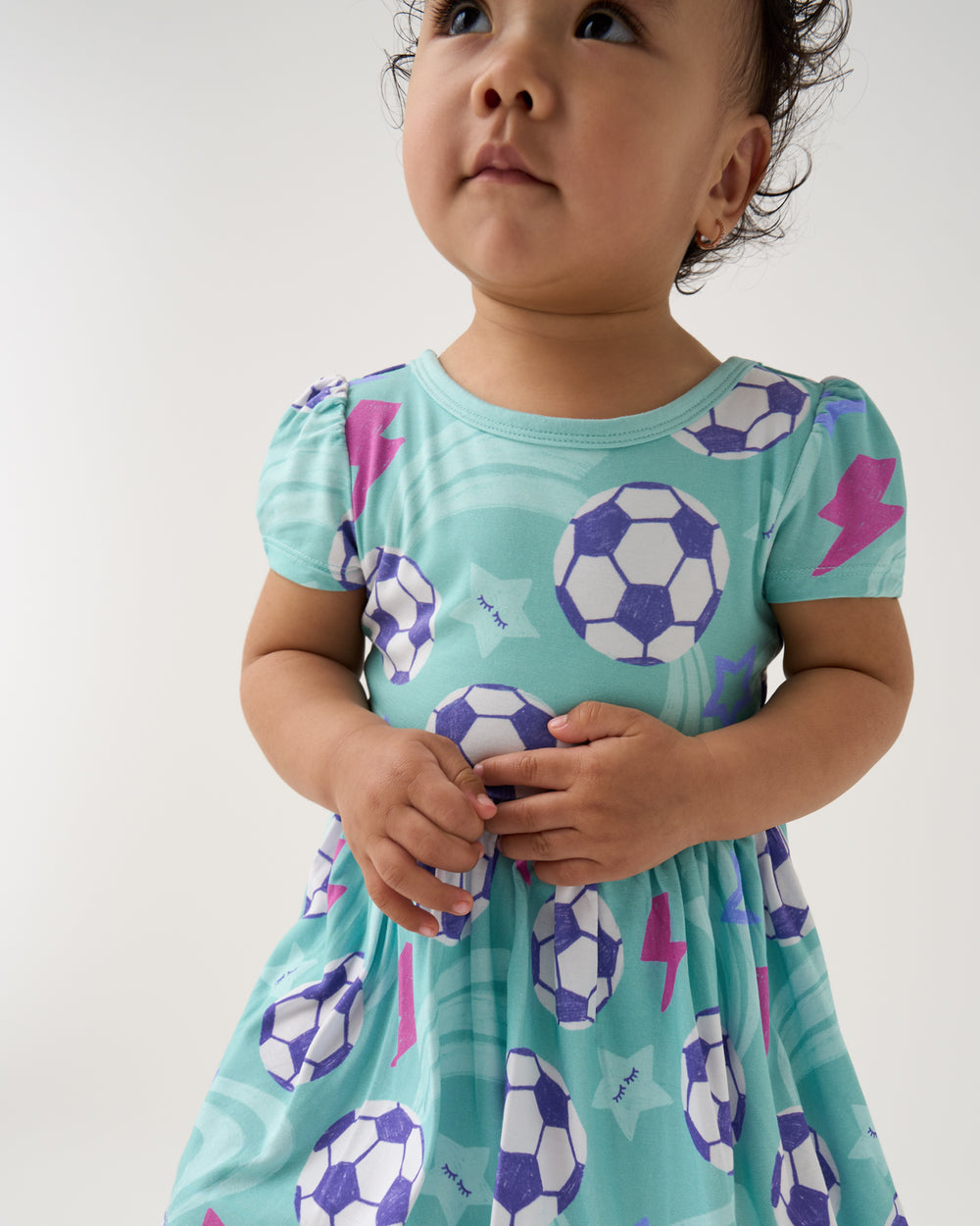 Close up of baby wearing the Aqua Soccer Stars Skater Dress with Bodysuit