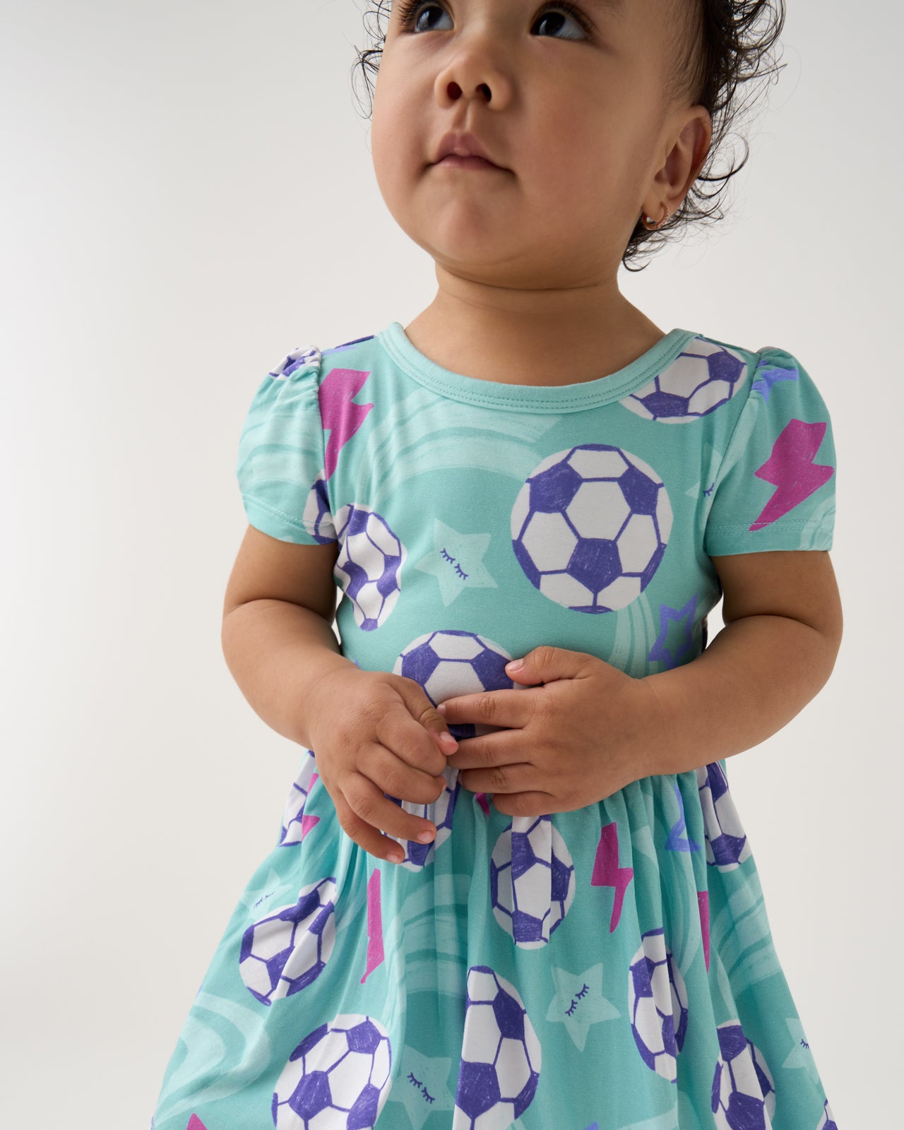 Close up of baby wearing the Aqua Soccer Stars Skater Dress with Bodysuit