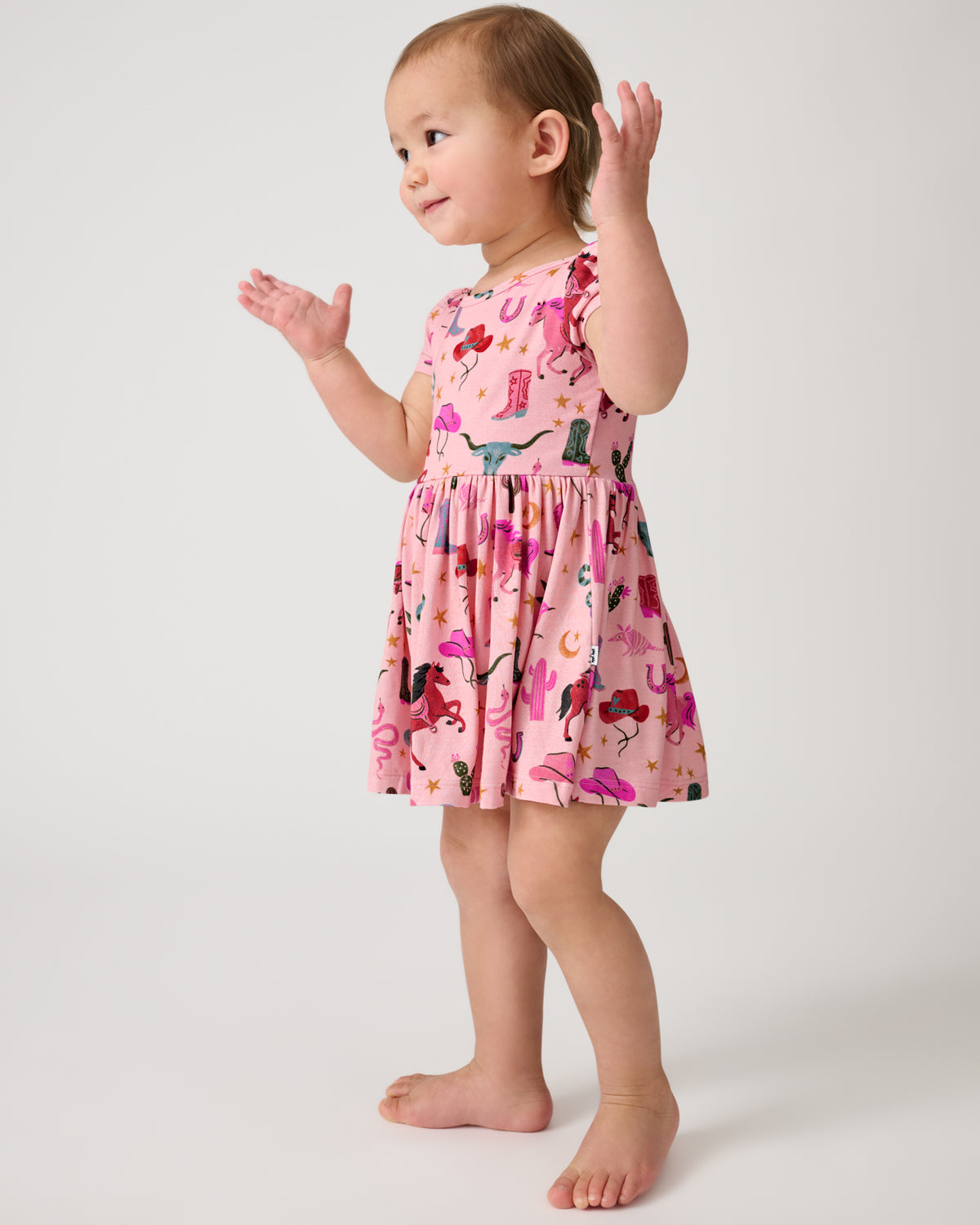 Standing child wearing the Pink Rancher Roundup Skater Dress with Bodysuit