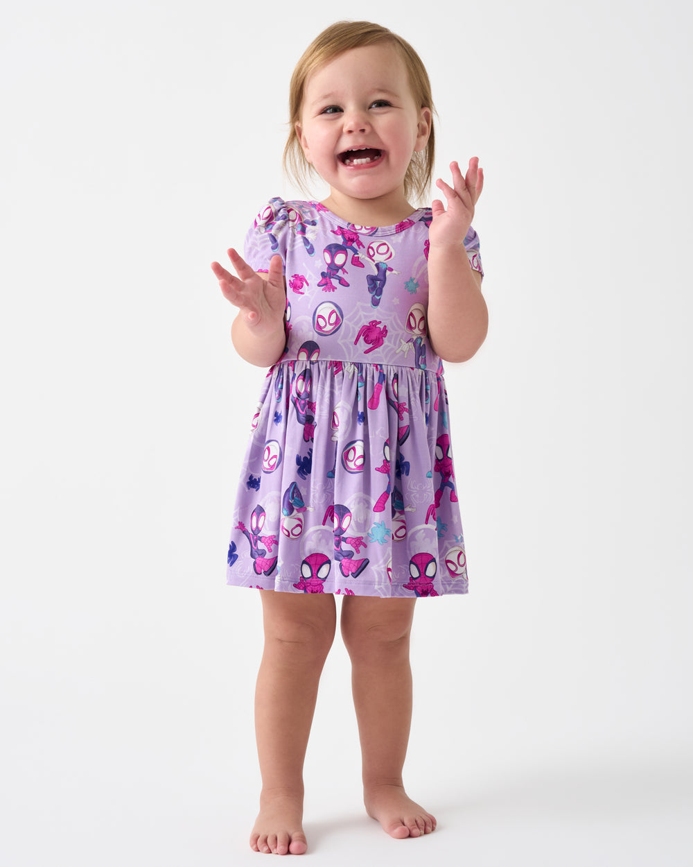 Clapping child wearing the Spidey & Friends Tiny Webs Skater Dress with Bodysuit