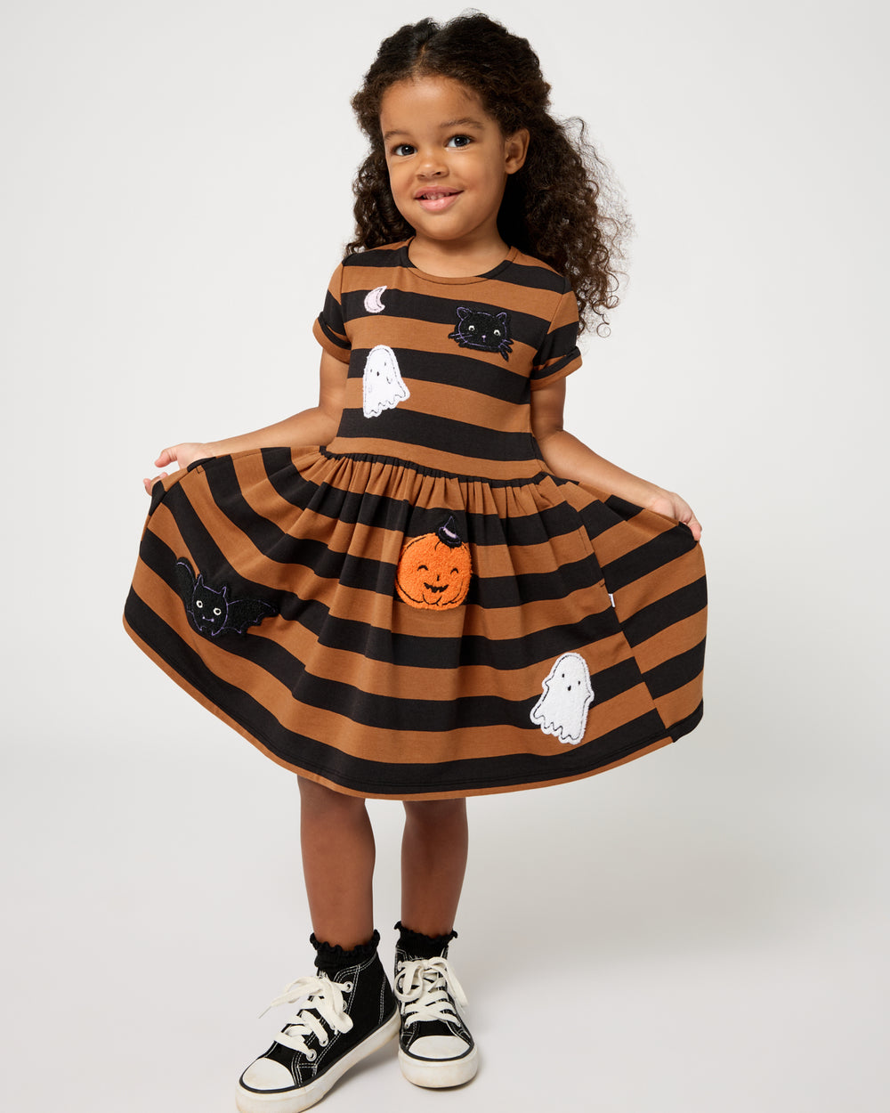 Girl wearing the Spooky Stripes Dress holding the skirt out