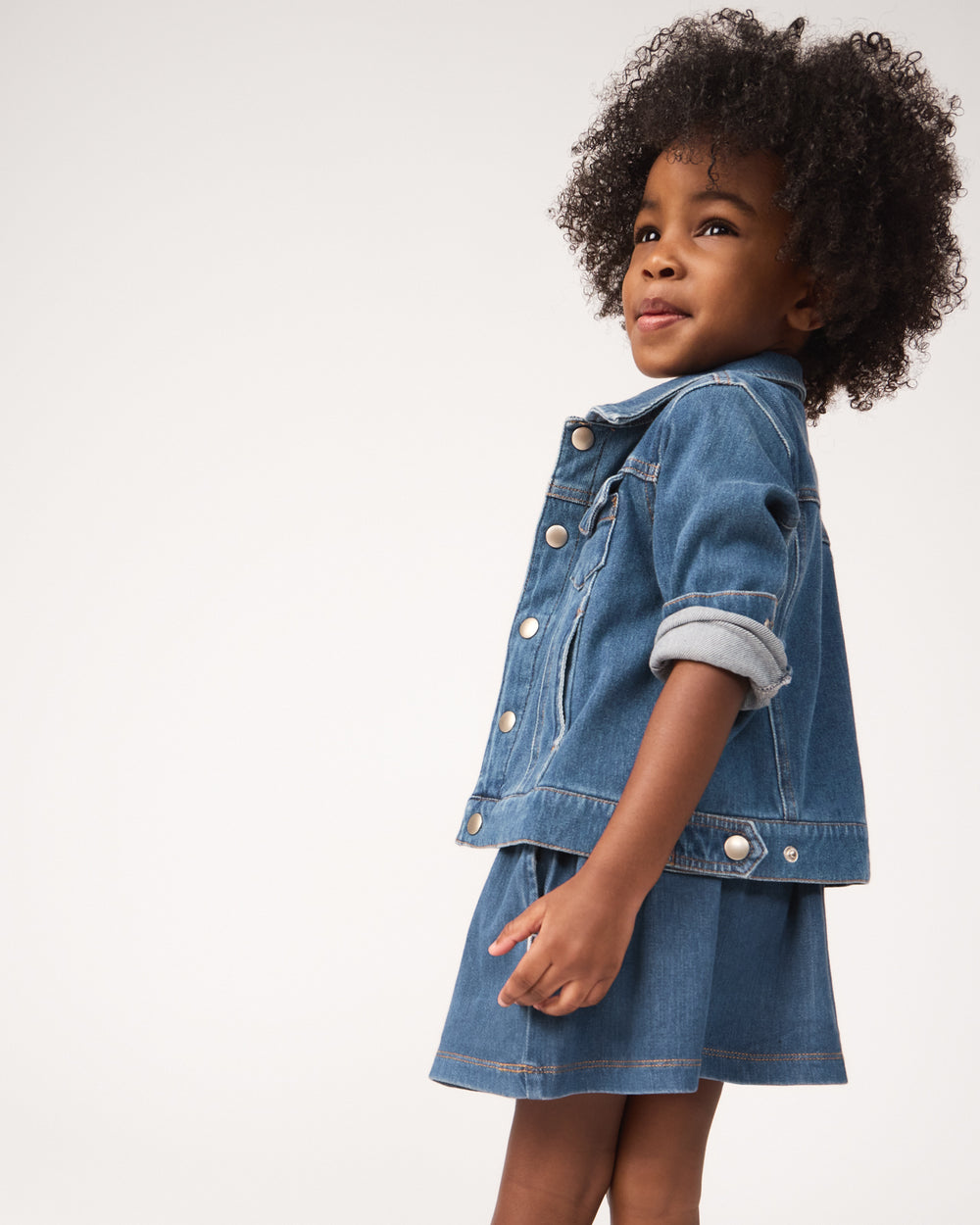 Girl wearing the Midwash Blue Denim Trucker Jacket and Skort