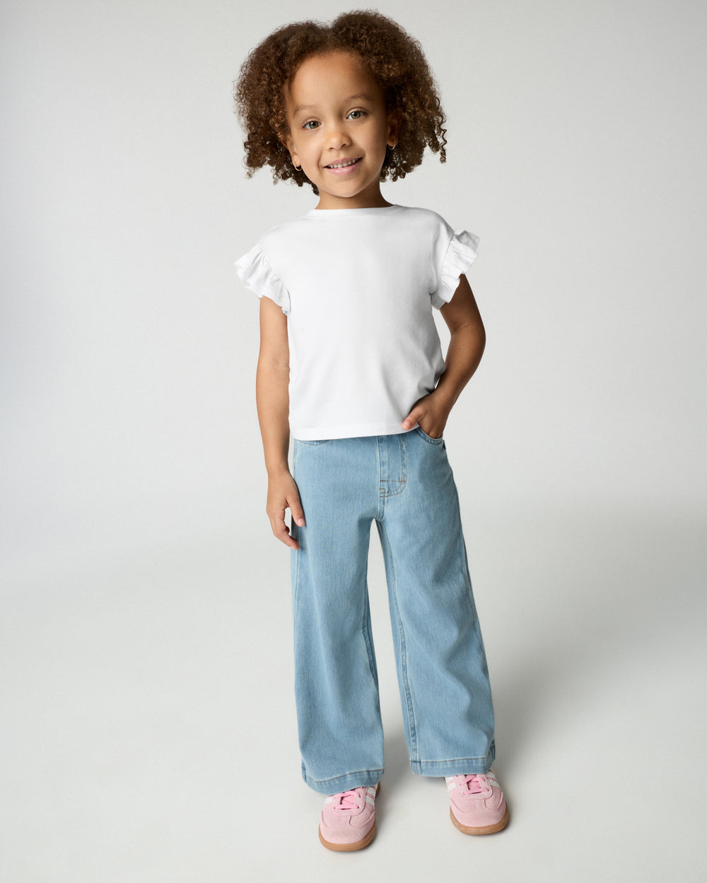 Girl wearing the Bright White Flutter Tee with wide leg denim pants