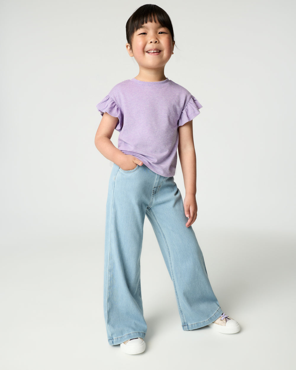 Girl wearing the Heather Lavender Flutter Tee with wide leg denim pants